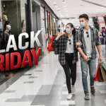 Shoppers browsing discounted products during Black Friday as footfall declines.